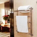 Modern heated towel rail on tiled in hotel